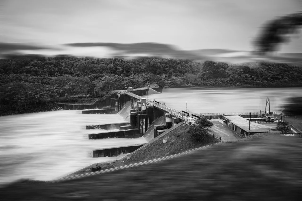 Fotografía en blanco y negro de una central hidroeléctrica entre montañas